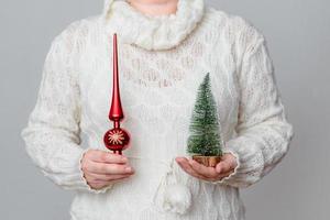 Frau hält einen Weihnachtsbaum und ein Ornament foto