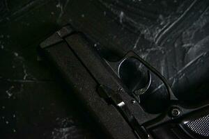 Pistole auf schwarzem Texturtisch. foto