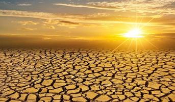 trockener Lehmboden Sonne Wüste globales Wurmkonzept rissige verbrannte Erde Boden Dürre Wüstenlandschaft dramatischer Sonnenuntergang foto