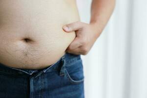 Mann mit Fett Bauch im Diät Konzept. Übergewicht Mann berühren seine Fett Bauch und wollen zu verlieren Gewicht. foto