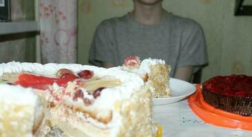 süß wenig Junge weht aus das Kerzen auf ein Geburtstag Kuchen beim heim. Kinder Geburtstag foto