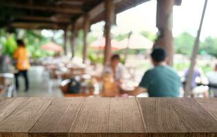 leeren dunkel hölzern Tabelle im Vorderseite von abstrakt verschwommen Bokeh Hintergrund von Restaurant . können Sein benutzt zum Anzeige oder Montage Ihre Produkte.mock oben zum Raum. foto