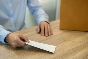 Senden Rücktritt Brief zu Boss und halten Zeug zurücktreten drücken oder Tragen Karton Box durch Schreibtisch im Büro foto