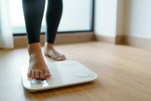 verlieren Gewicht. Fett Diät und Rahmen Füße Stehen auf elektronisch Waage zum Gewicht Kontrolle. Messung Instrument im Kilogramm zum Diät. foto