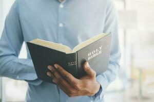 Mann halten und lesen das heilig Christian Bibel. foto