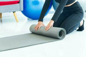 gesund Lebensstil Konzept. schließen oben gesund Frau vorbereiten Yoga Matte Vor trainieren im das Leben Zimmer foto