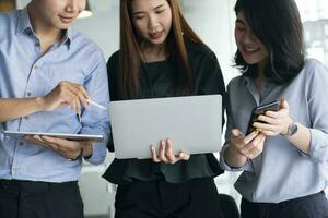 Teen Gruppe mit Computer und Tablette zu suchen und Lernen online. foto