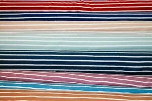 Detaillierte Nahaufnahme von Mustern von Stoffen und Stoffen in verschiedenen Farben, die auf einem Stoffmarkt gefunden wurden foto