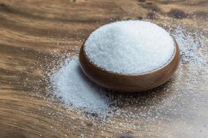 weißer Zucker auf Holzboden foto