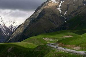 Aussicht von Berge mit Autos Fahren auf gebogen Straße im Georgia foto