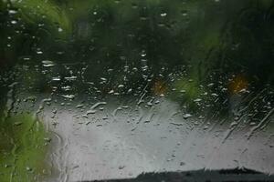 verschwommen Bild von Regentropfen auf das Rückseite Aussicht Spiegel von Auto, Sanft Fokus foto