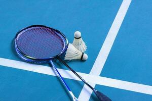 Cremeweißer Badminton-Shuttlecock und Schläger auf dem Boden im Indoor-Badmintonplatz, Kopierraum, weicher und selektiver Fokus auf Federbälle. foto