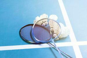 Cremeweißer Badminton-Shuttlecock und Schläger auf dem Boden im Indoor-Badmintonplatz, Kopierraum, weicher und selektiver Fokus auf Federbälle. foto