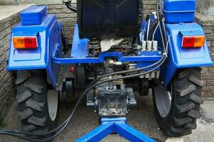 landwirtschaftlich Maschinen. Mini Traktor zurück Aussicht von Straße foto