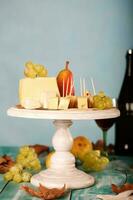 Käse Scheiben, Birne, und Trauben auf ein hölzern Stand. foto
