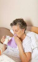 Senior Frau getrunken etwas Milch von das Glas foto