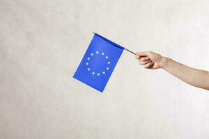 ein Hand mit ein Flagge von das EU. kostenlos Raum zum ein Text foto