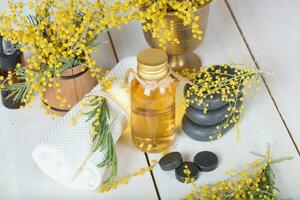 Mimose Blumen Massage Öl im Glas Flasche. foto