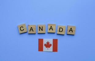 August 7, bürgerlich Urlaub im Kanada, staatsbürgerlich Tag Urlaub, Flagge von Kanada, minimalistisch Banner mit hölzern Briefe auf ein Blau Hintergrund foto