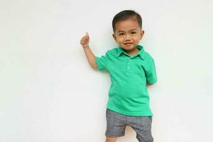 Porträt von ein glücklich wenig asiatisch Junge suchen beim Kamera während schreien auf das Weiß Hintergrund foto