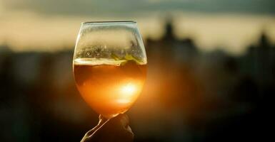Glas von Wein oder Champagner auf Sonnenuntergang. foto