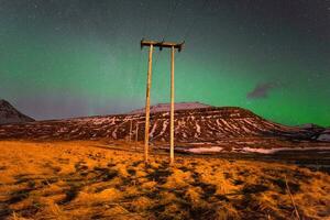 elektrisch Pole unter das Nord Beleuchtung im das Landschaft von Island. foto