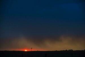 Pampas Windmühle Landschaft beim Sonnenuntergang Sturm, la Pampa Provinz, Argentinien foto