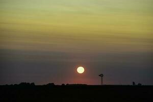 Windmühle im Landschaft beim Sonnenuntergang, Pampas, Patagonien, Argentinien. foto