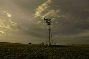 Windmühle im Landschaft beim Sonnenuntergang, Pampas, Patagonien, Argentinien. foto