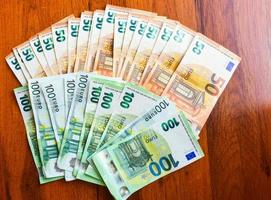 zweitausend Euro verteilt auf Holztischhintergrund Draufsicht top