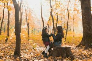 wenig Mädchen spielen mit Mutter im das Herbst Park foto