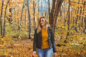 Mädchen hält gefallen Blätter und Spaziergänge im Herbst Park. saisonal Konzept. foto