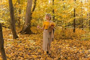 Porträt von schön jung Frau Gehen draußen im Herbst. fallen Jahreszeit und stilvoll Mädchen Konzept. foto