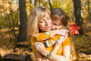 jung Mutter mit ihr wenig Tochter im ein Herbst Park. fallen Jahreszeit, Erziehung und Kinder Konzept. foto