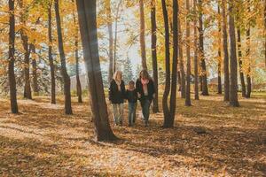 Oma und Mutter mit Enkelin Spaziergänge zusammen im Herbst Park und haben Spaß. Generation, Freizeit und Familie Konzept. foto