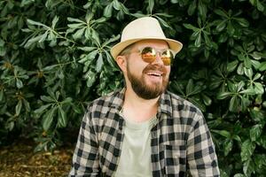 Lachen attraktiv Mann tragen Hut Über Grün Baum Hintergrund - - Emotion und Ferien Reise Ferien Konzept foto