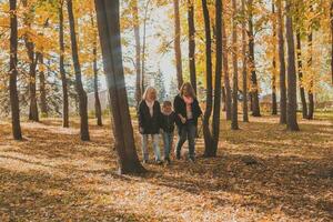 Oma und Mutter mit Enkelin Spaziergänge zusammen im Herbst Park und haben Spaß. Generation, Freizeit und Familie Konzept. foto