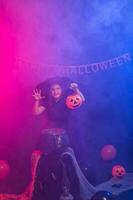 komisch Kind Mädchen im Hexe Kostüm zum Halloween mit Kürbis Jack. foto