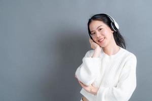 junge asiatische frau, die musik mit kopfhörern hört foto