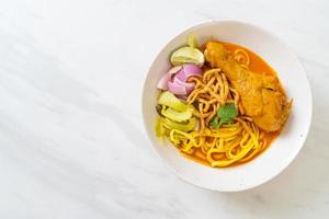 Nordthailändische Nudel-Curry-Suppe mit Hühnchen foto