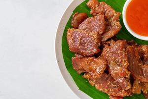sonnengetrocknetes Schweinefleisch mit Soße auf einem Teller foto
