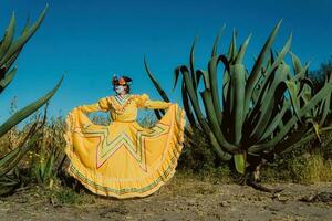 Mexikaner Frau im bunt Kleid und Schädel bilden im das Mexikaner Wüste Kaktus foto