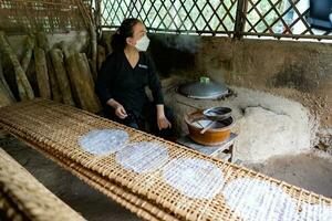 cu chi, viet nam - - 20 kann 2023 frisch gemacht Reis Papier ist Trocknen auf Bambus Tabelle zum Produktion von Knödel und Frühling Rollen im das cu Chi Tunnel. berühmt Tourist Attraktion im Vietnam. Lager Foto