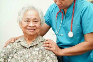 Arzt Hilfe asiatisch Alten Frau Behinderung geduldig Sitzung auf Rollstuhl im Krankenhaus, medizinisch Konzept. foto