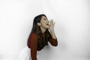 jung schön Frau tragen ein rot oben schreien und schreiend laut mit ein Hand auf ihr Mund. Kommunikation Konzept. foto