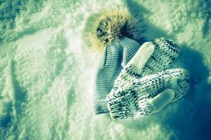 Winter Hut und Handschuhe Lügen hat verloren im das Schnee auf das Straße foto