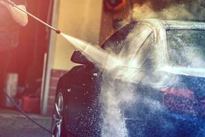 Auto Waschen mit Druck Wasser Pistole. foto