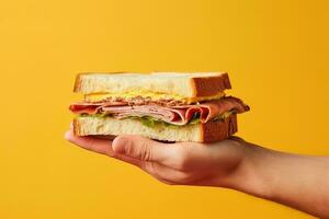 Hand halten lecker Sandwich auf ein Gelb Hintergrund. ai generiert foto