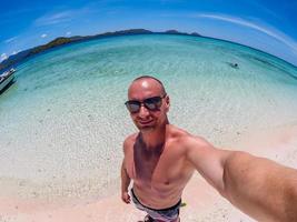 Kaukasischer Mann macht Selfie am Strand von Flores Taka Makassar foto