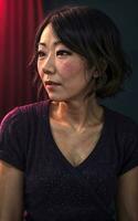 Porträt Foto von schön Mitte alt asiatisch Frau im dunkel Zimmer mit Licht im Hintergrund, generativ ai